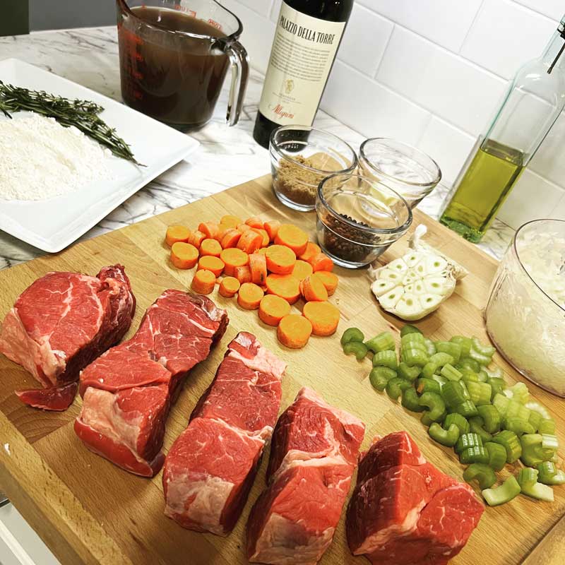 meat-cutting-board-wine A cutting board full of meat vegetable and a side of wine